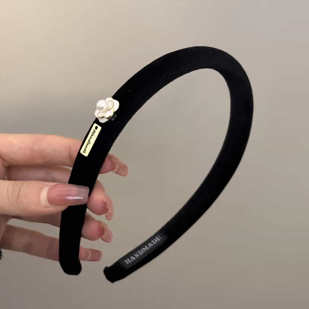 Black velvet headband with pearl flower and handmade tag.